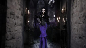 Model wearing a gothic black steampunk corset and layered purple skirt in a dark Victorian candle-lit room