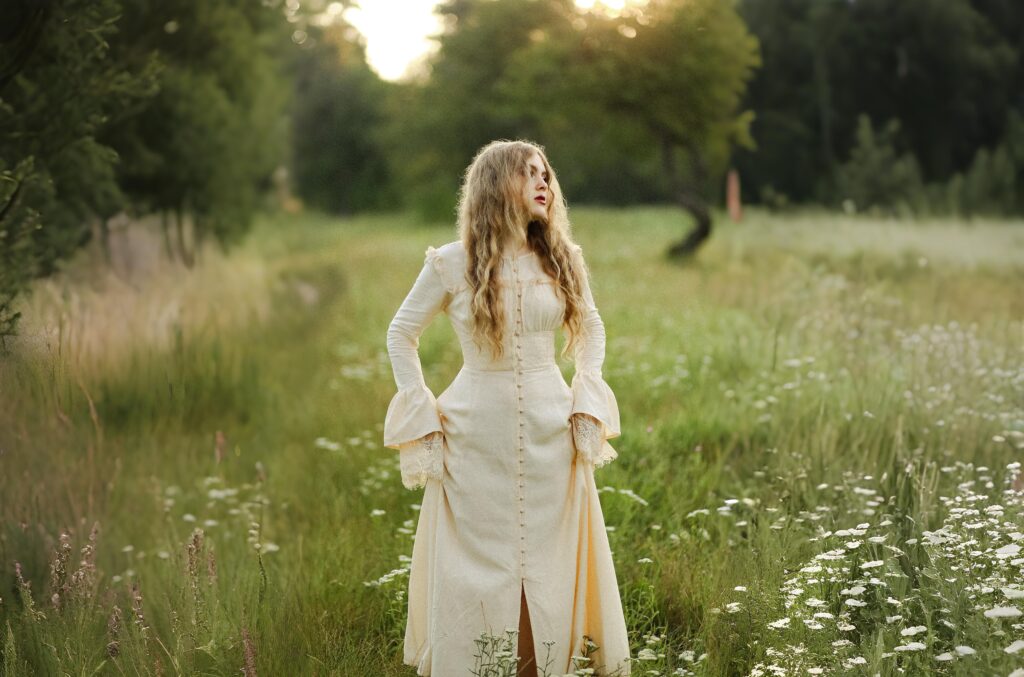 Romantic cottagecore dress with lace cuffs and vintage button-down design, worn in a wildflower meadow at sunset.