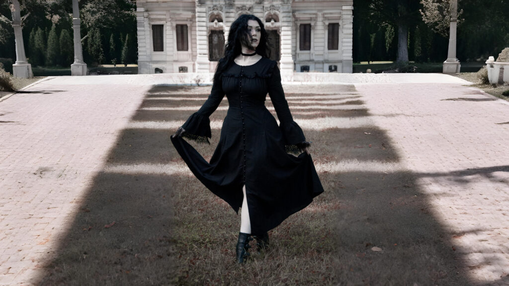 Model wearing a black gothic Renaissance dress with flared sleeves and button-down design from The Pirate Dressing, styled in a vintage courtyard setting.